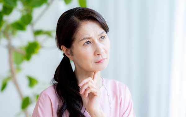 考え事をしているシニア女性
