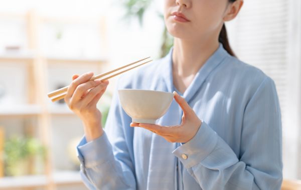 朝食を食べてほほ笑む女性